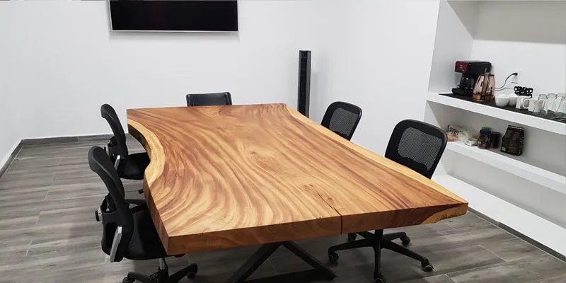 Boardroom with a live-edge wooden table, office chairs and a coffee niche