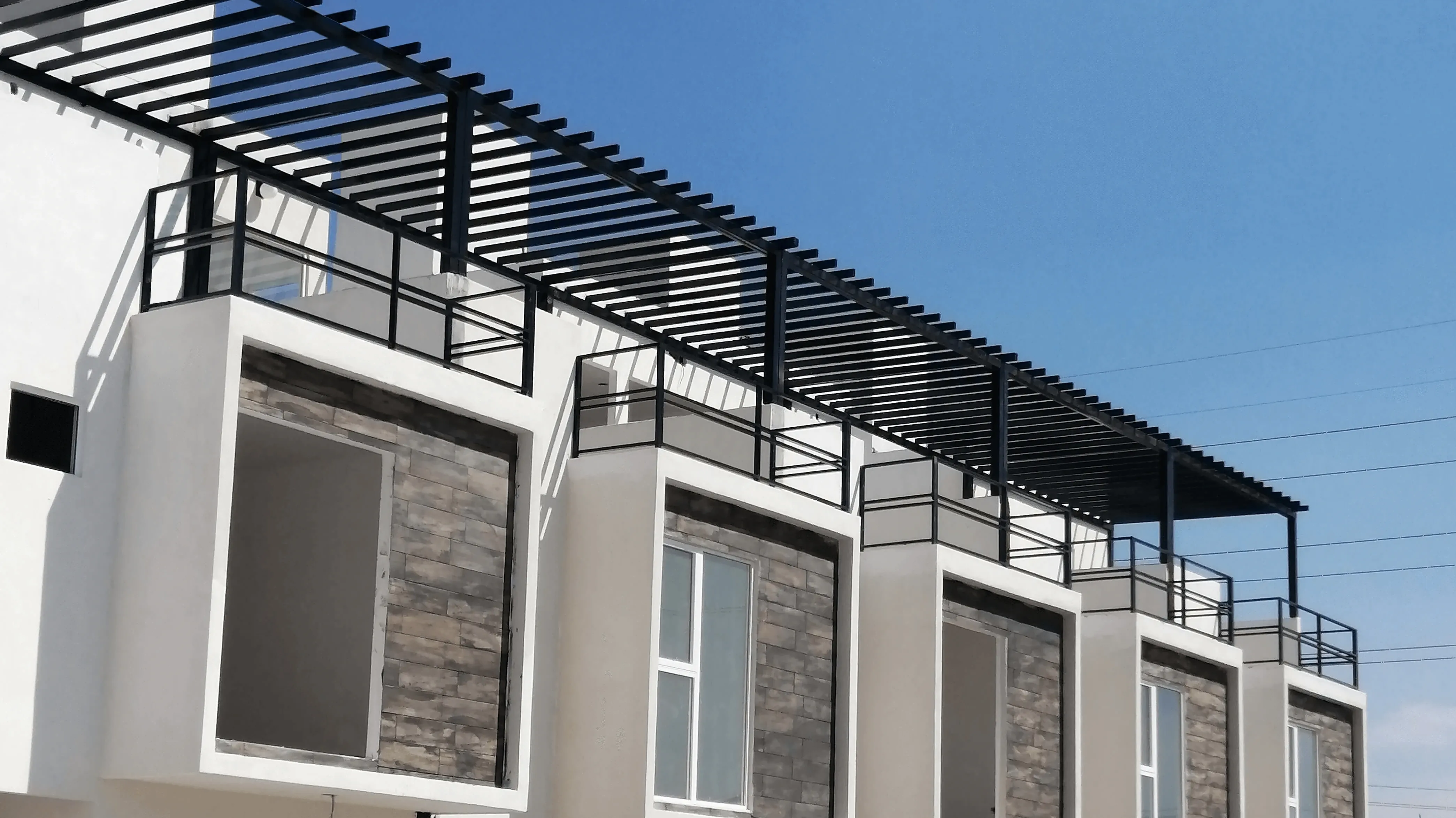 Iron pergola and railings installed on the rooftop of a row of houses in Tijuana
